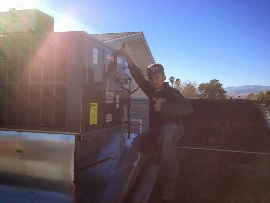 HVAC technician performing Boiler Repair on a rooftop unit in Town and Country